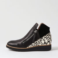 Black wedge shoe with leopard print heel on a light gray background