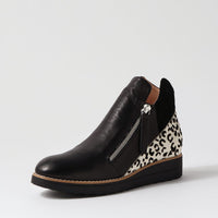 Black wedge shoe with leopard print heel on a light gray background