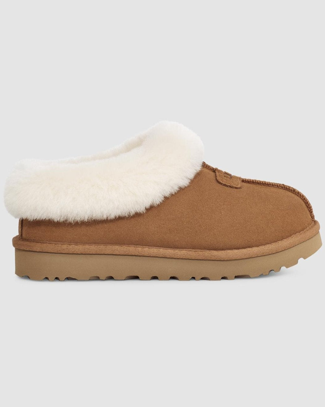 Brown slipper with white fur lining on a light gray background