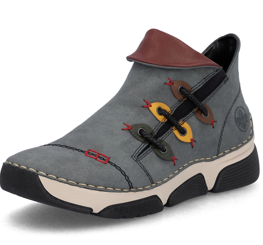 A gray suede ankle boot with a brown leather collar, black laces, and decorative colorful eyelets in yellow, brown, and green. The boot features a beige midsole and a black outsole, shown on a white background.